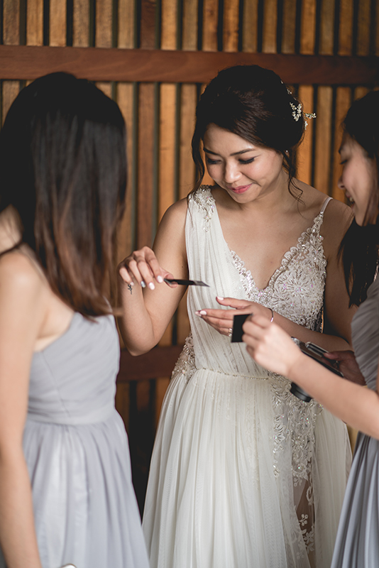 Bride with bridesmaid looking at a polaroid candid shot